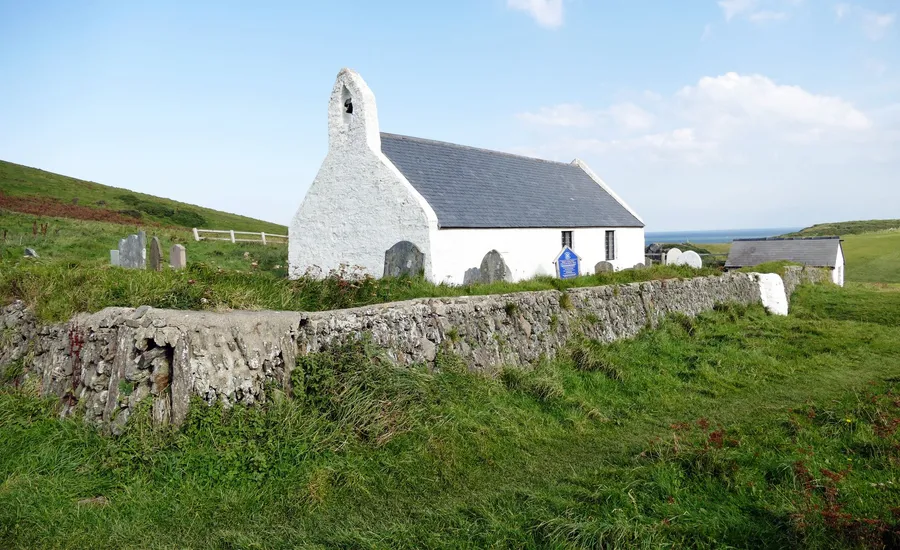 A whitewashed Welsh chapel with a slate roof behind a dry stone wall, the kind of Nonconformist chapel architecture common in Pen-y-groes